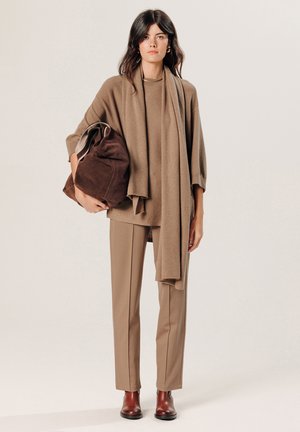 Brauner oversized Pullover mit passendem Schal, beigen maßgeschneiderten Hosen, braunen Leder-Ankle Boots und einer dunkelbraunen Wildledertasche. Glatte Textur.