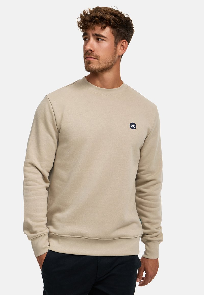 Beige Sweatshirt mit Rundhalsausschnitt, gerippten Bündchen und Saum. Mit einem kleinen dunklen Logo auf der Brust. Weicher, strukturierter Stoff.