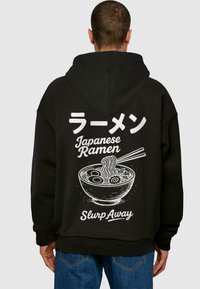 Čierna mikina s kapucňou, ktorá na chrbte obsahuje biely grafický text v japončine a angličtine, spolu s ilustráciou misy ramen a paličiek.