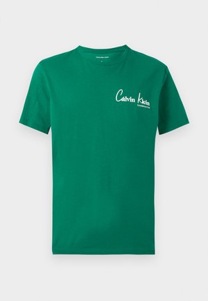 Grønn T-skjorte med korte ermer og rund hals, med hvit Calvin Klein-logo og teksten "Established 1946" på venstre bryst.