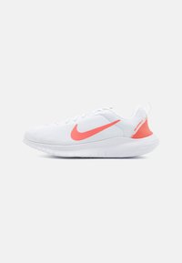 Hvid atletiksko med en overdel i mesh, pink accenter og en polstret sål. Har et fremtrædende swoosh-logo og et struktureret design.