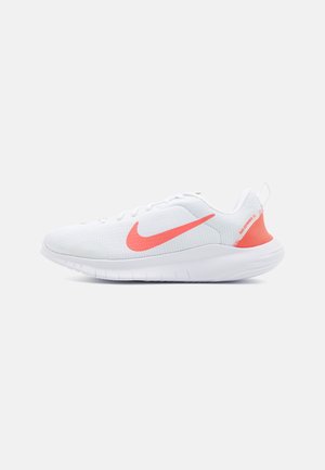 Chaussure de sport blanche avec une tige en maille, des accents roses et une semelle rembourrée. Présente un logo swoosh bien en vue et un design texturé.