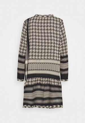 Langærmet kjole med sort, beige og gråt hundetands- og stribemønster, vist bagfra mod en hvid baggrund.