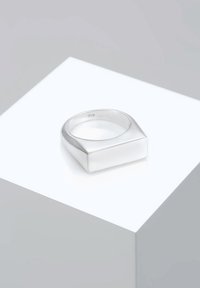 Ring i sterling sølv med et geometrisk design og flad top. Har en glat overflade og er stemplet med "925", som angiver sølvindholdet.