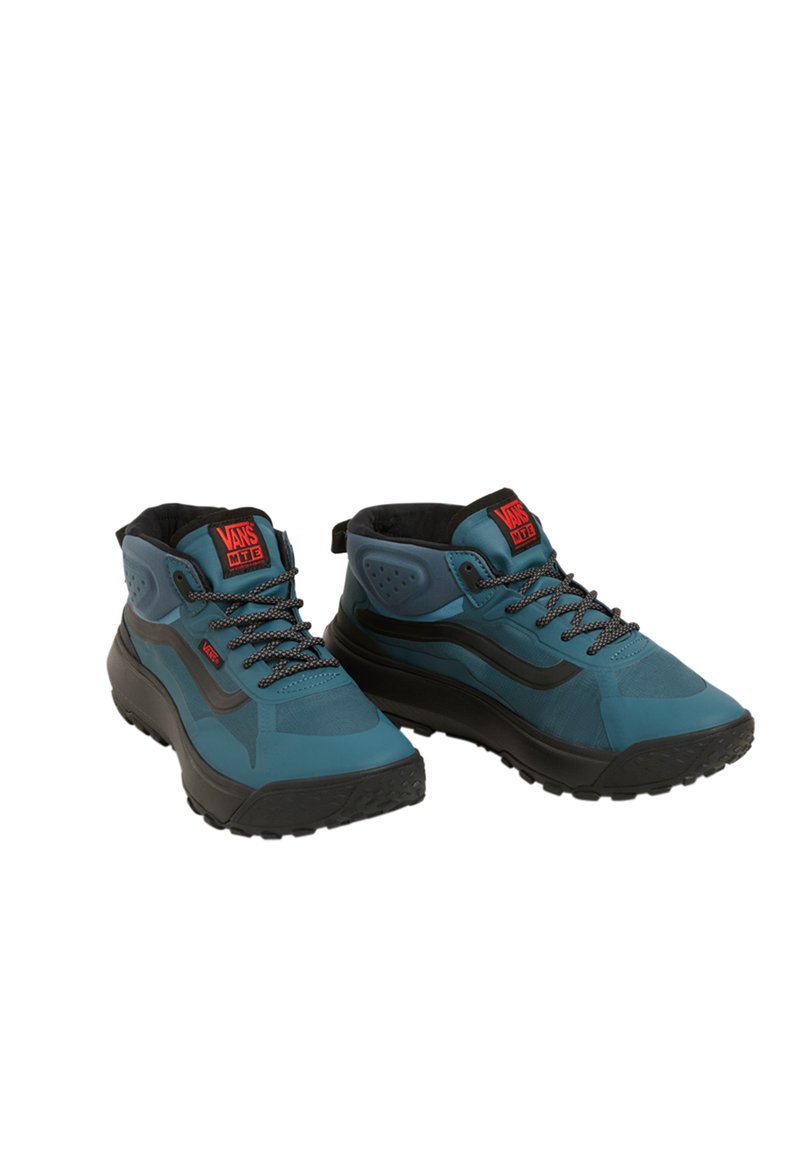 Zapatillas altas en teal y negro con parte superior texturizada, suela de goma negra, cordones redondos y logo rojo de Vans en la lengüeta.