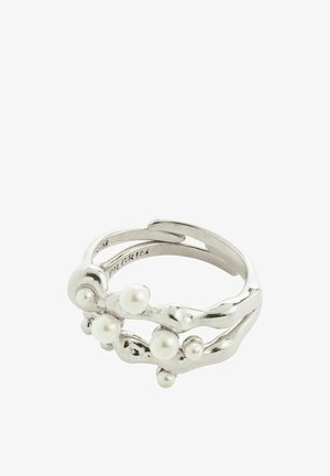 Sudraba krāsas metāla gredzens ar viļņotu dizainu, kurā ir iegruvis mazas baltas pērles, radot teksturētu izskatu visā virsmā.