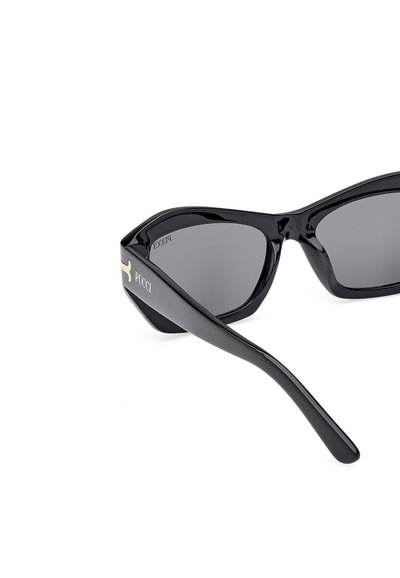 Gafas de sol negras con forma geométrica de ojo de gato, lentes grises, montura de plástico brillante y detalle del logo dorado "Pucci" en el costado.