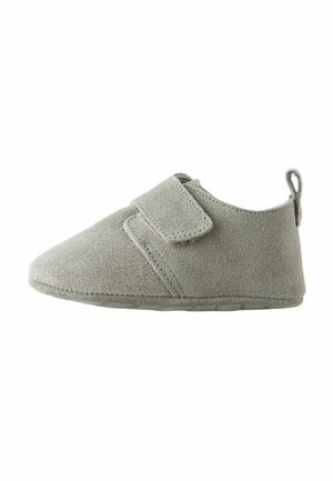 Grau Wildleder-Slipper mit einem Klettverschluss, runder Zehenpartie, weicher Textur und einem kleinen Absatz. Minimalistisches Design, geeignet für den Innenbereich.