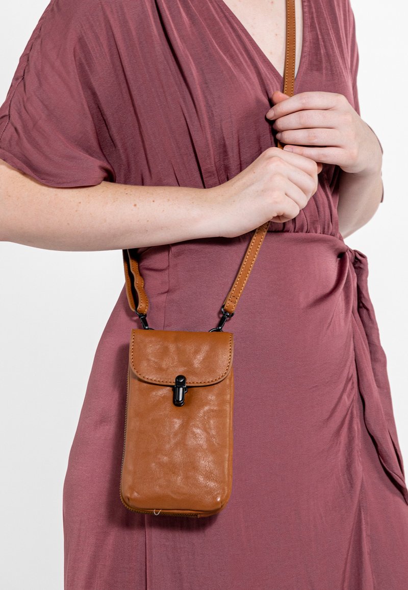 Borsa a tracolla in pelle marrone con chiusura a pattina e accessori neri. Texture liscia con forma rettangolare e tracolla regolabile.