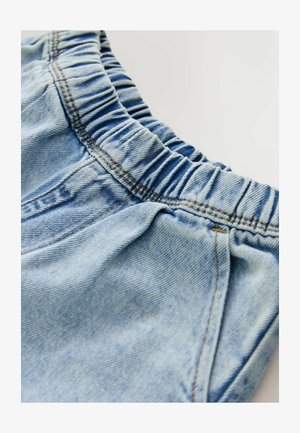 Vaaleansiniset farkkushortsit, joissa on joustava vyötärö, näkyvillä saumoilla ja pehmeällä tekstuurilla, suunniteltu mukavuutta ja helppokäyttöisyyttä varten.