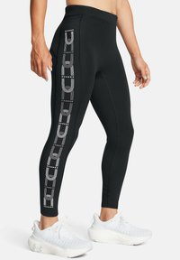 Leggings neri realizzati in tessuto elasticizzato, con lettere e linee bianche sui lati, progettati per l'abbigliamento sportivo.