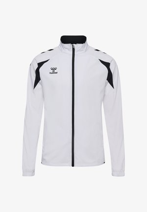Biała kurtka sportowa z czarnymi akcentami na ramionach, pełnym zamkiem z przodu, elastycznymi mankietami i małym czarnym logo Hummel na piersi.