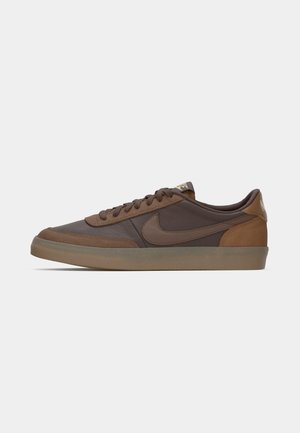 Brown low-top Nike sneaker with suede and leather panels, brown laces, and a translucent gum sole, shown from the side on a white background.