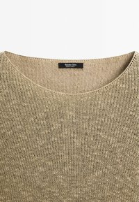 Maglione beige lavorato a maglia con un ampio scollo rotondo, design testurizzato e piccolo etichetta del marchio. Realizzato in tessuto leggero.