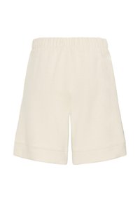 Shorts beiges à taille élastique avec une coupe décontractée et des ourlets retroussés, conçus pour une tenue décontractée.
