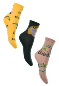 Drei Paar bunte Socken: gelb mit Tiermotiven, dunkelgrün mit einem Cartoon-Gesicht und hellbraun mit grünen und roten Text.