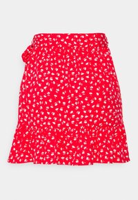 Falda roja con estampado de flores blancas, con dobladillo con volante y una cinturilla con un lazo lateral. Hecha de una tela ligera.