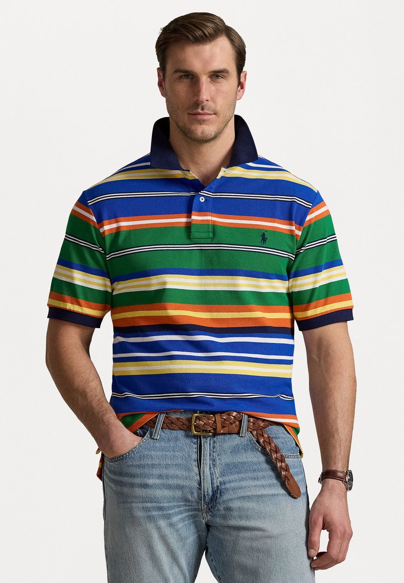 Striped polo shirt in blue, green, orange, and yellow with a navy collar. Worn with light blue jeans and a braided brown belt.