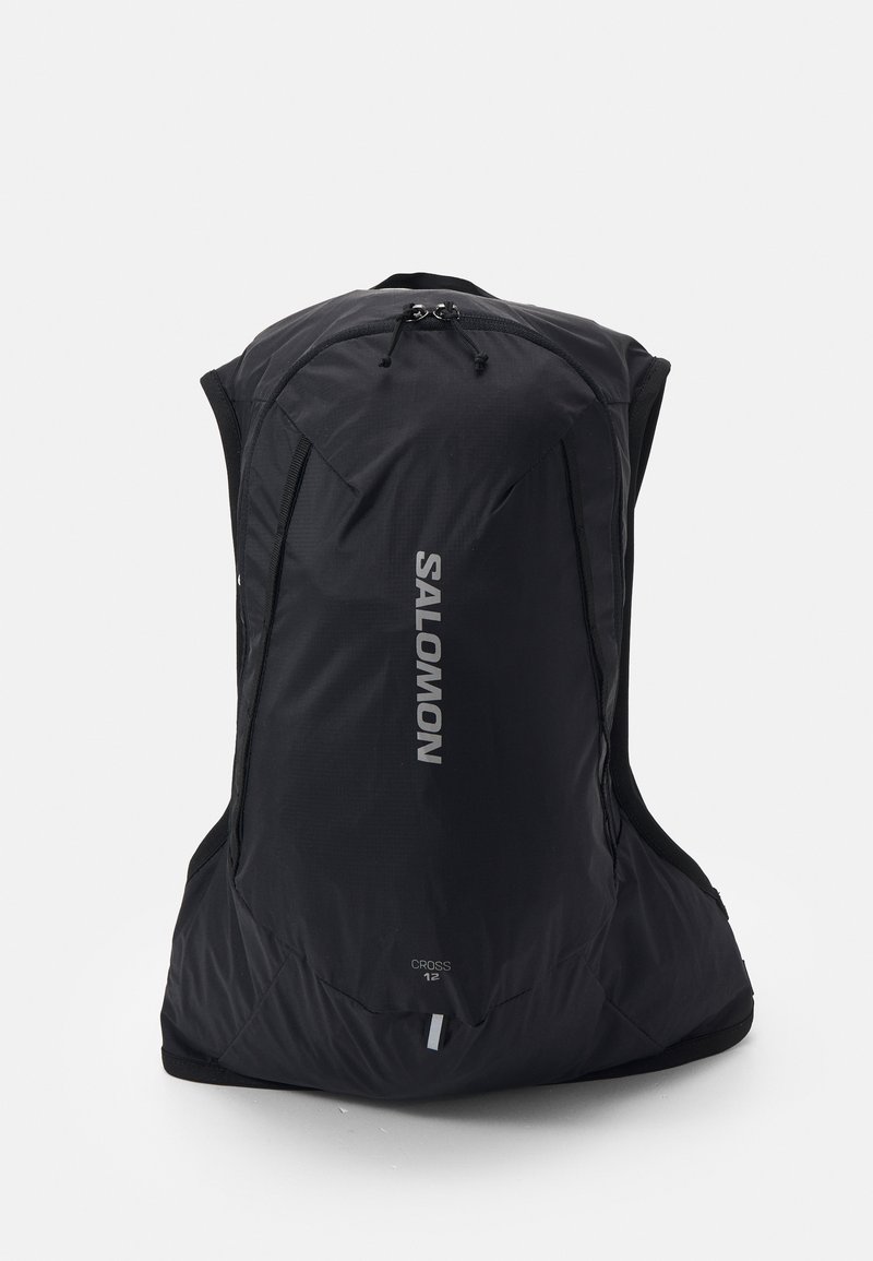 Mochila de exterior preta com um design aerodinâmico, fabricada em material leve; apresenta um logótipo proeminente, bolsos com fecho e tiras ajustáveis.