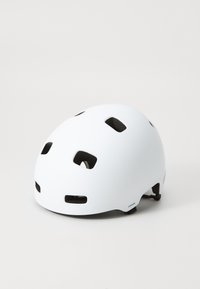 Casco bianco realizzato in plastica dura, dotato di fori di ventilazione e finitura opaca. Include imbottiture marroni e cinturini regolabili per una vestibilità perfetta.