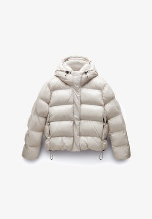 Giacca beige imbottita con cappuccio, caratterizzata da una finitura lucida, cuciture visibili, due tasche laterali e cordini regolabili all'orlo.