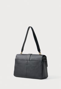 Bolsa de mão em pele preta com uma forma estruturada, apresentando uma alça superior, acabamentos em tom dourado e superfície texturizada.