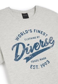 Szara bawełniana koszulka z okrągłym dekoltem i niebieskim nadrukiem graficznym z napisem "Najlepsze ubrania na świecie by Diverse" w stylu retro.