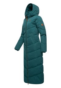 Lange teal pufferjas met capuchon, voorzien van een rits aan de voorkant, zijzakken en een schuin gestikt patroon. Bruine accenten op de rits en de mouwen.