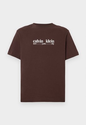Brūna īsroku kokvilnas t-krekls ar īsām piedurknēm. Priekšpusē ir balti uzraksti "calvin klein new york city". Klasisks apaļš kakla izgriezums.