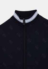 Veste de sport bleu marine avec un col montant, un col côtelé bicolore rayé et un motif subtil de logo. Comprend un détail de fermeture éclair centrale.