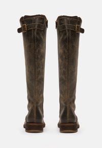 Botas altas de cuero marrón con un acabado desgastado, con un cierre de cremallera lateral, un detalhe de correa en la parte superior y un tacón apilado.