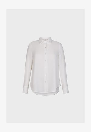 Camisa blanca de manga larga hecha de un tejido suave, con un cierre de botones en la parte delantera y un dobladillo curvado con mangas abotonadas.