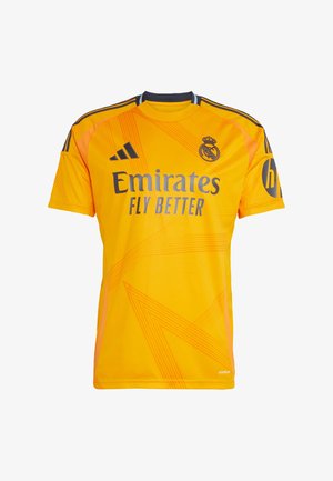 Żółta koszulka sportowa z syntetycznego materiału, z okrągłym dekoltem, krótkimi rękawami i geometrycznymi wzorami. Na koszulce znajdują się loga "Emirates" i Adidas.