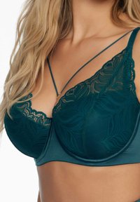 Braletka w kolorze turkusowym z koronkowym wzorem, z fiszbinami i regulowanymi ramiączkami. Gładki materiał z dekoracyjnym koronkowym wykończeniem na miseczkach.