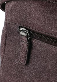 Borsa in pelle viola testurizzata con tasca con cerniera, hardware in metallo e una linguetta in pelle con il nome del marchio impresso.