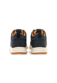 Schwarze Sportschuhe mit strukturiertem Obermaterial, orangefarbenen Akzenten und einer gepolsterten weißen Sohle mit einer Gummisohle. Verstärkter Fersenschaft inklusive.