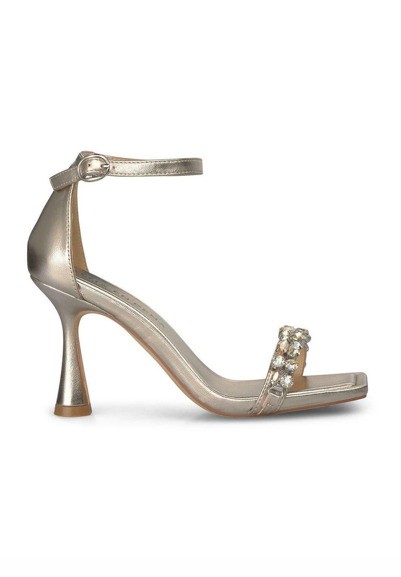 Sandal de tacón alto metálico dorado con correa en el tobillo, punta descubierta y acentos decorativos de rhinestone en la parte delantera. Textura suave y forma elegante.
