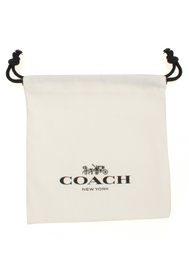 Biały woreczek ze sznurkiem w kolorze czarnym, z logo Coach New York i wzorem powozu konnego umieszczonym na środku z przodu.