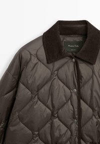 Bruine gewatteerde jas met een gestructureerde, donkere corduroy kraag. Voorzien van drukknoopsluiting en een gladde buitenkant die de ruitpatronen benadrukt.