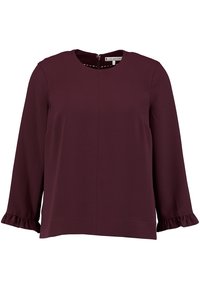 Dunkellila Bluse mit langen Ärmeln und rundem Ausschnitt, feinem strukturiertem Material, Reißverschluss auf der Rückseite und Rüschenausschnitten an den Ärmeln.