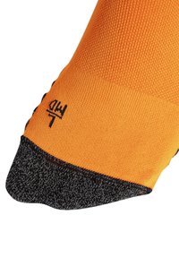 Orange sok med en tekstureret overdel og en sort mønstret tå. Inkluderer et subtilt logo broderet nær anklen.