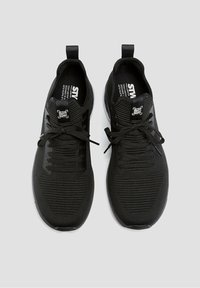 Černé sportovní boty s prodyšným síťovinovým svrškem, šněrováním a poutkem na patě. Plochá gumová podrážka s decentním brandingem.