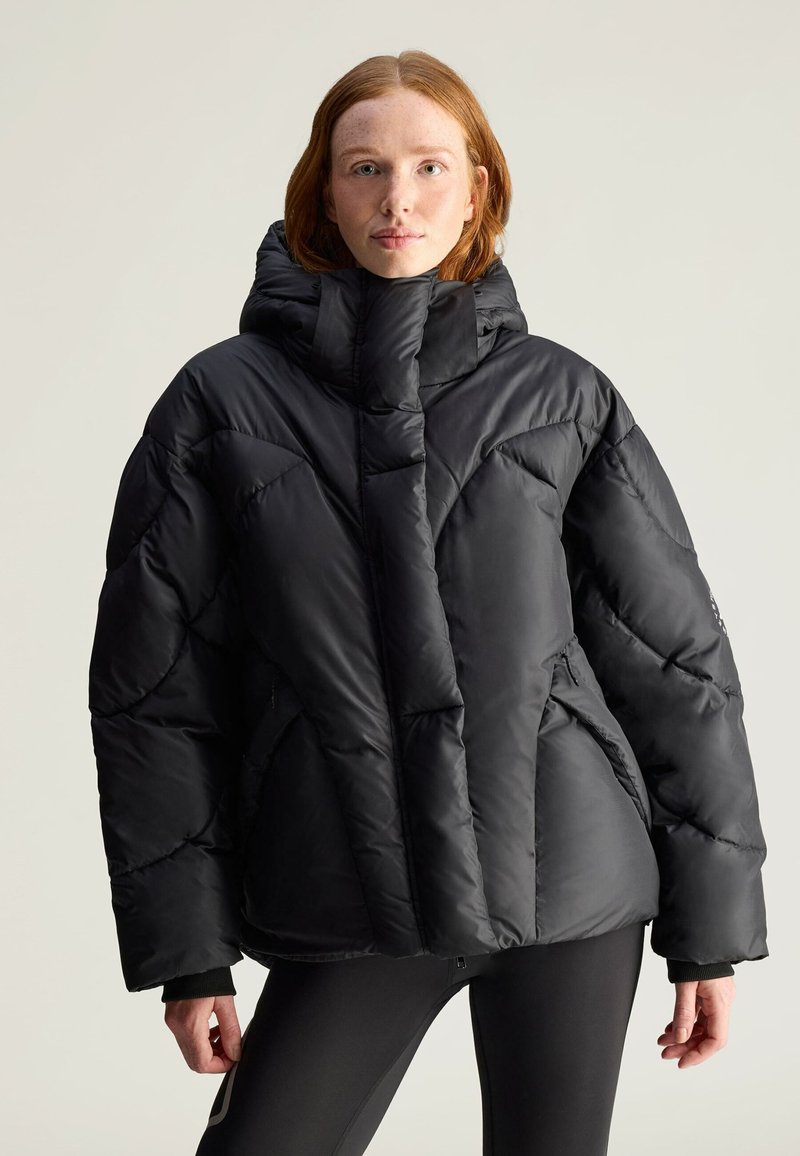 Czarna kurtka puchowa z wysokim kołnierzem, o pikowanym wzorze i miękkiej teksturze. Zawiera zamek błyskawiczny z przodu oraz ocieplenie.