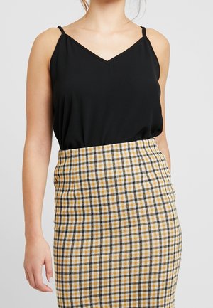 Top senza maniche nero con scollatura a V abbinato a una gonna a quadri gialla e nera, caratterizzata da una silhouette aderente e texture liscia.