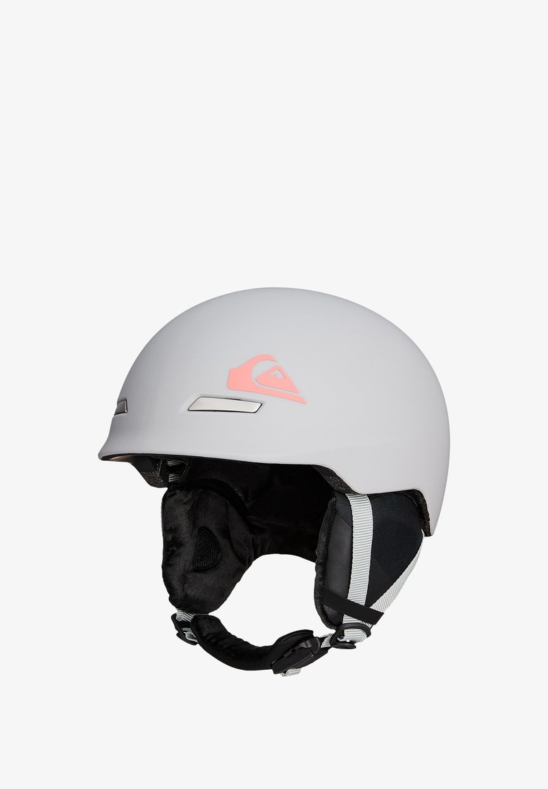 Matte lichtgrijze skihelmet met zwart gevoerde oorbedekkingen, verstelbare kinband en klein koraalkleurig logo aan de zijkant.