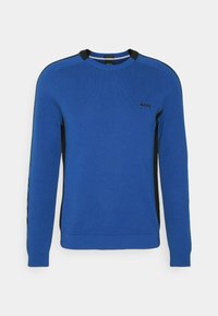 Maglione blu lavorato a maglia con accenti neri ai lati, colletto tondo e polsini a coste. Presenta un logo sul petto; texture liscia.