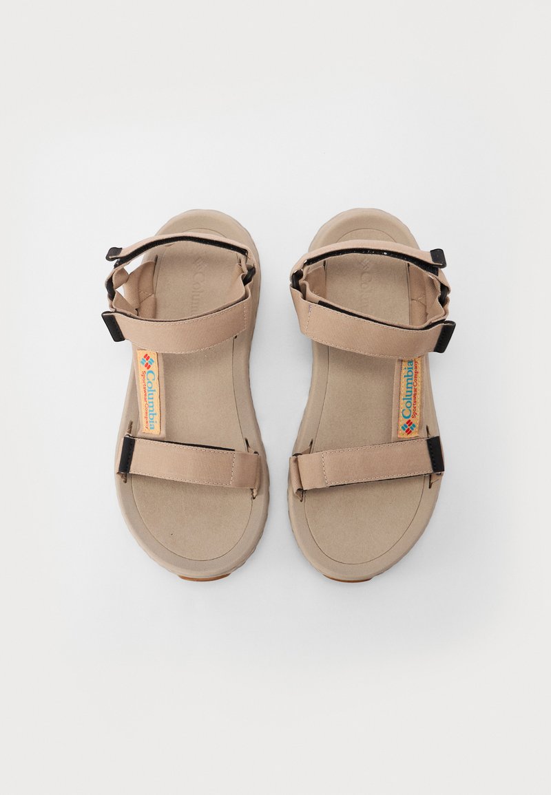 Beżowe sandały z dwiema regulowanymi paskami, miękką wkładką i teksturowaną gumową podeszwą. Logo Columbia umieszczone na wkładce.