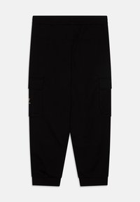 Schwarze Cargo-Hosen mit einem elastischen Bund, ausgestattet mit zwei seitlichen Taschen und einem schmal zulaufenden Bein-Design. Weicher Stoff mit einer glatten Textur.
