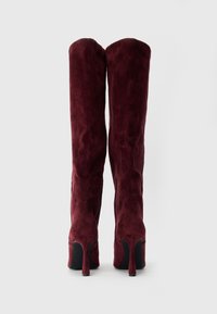 Stivali alti fino alla coscia in suede bordeaux con una texture liscia, punta affusolata e tacco a stiletto sottile. Design semplice senza hardware visibile.