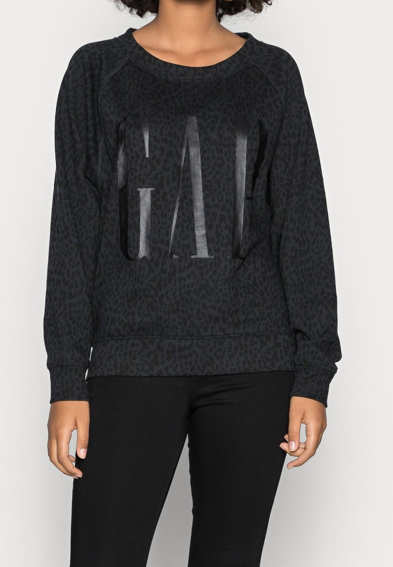 Sweat-shirt noir avec un motif léopard, arborant un graphique "GAL" brillant sur le devant, col rond et manches longues.